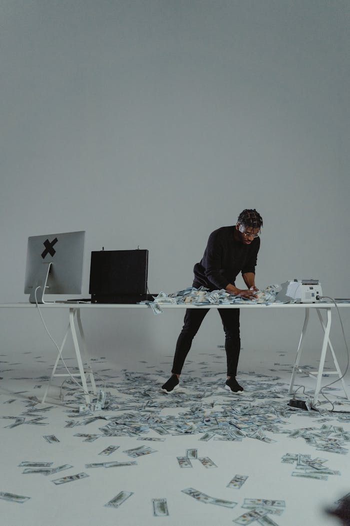 Businessman counting large sum of money on a desk, conveying themes of wealth and finance.